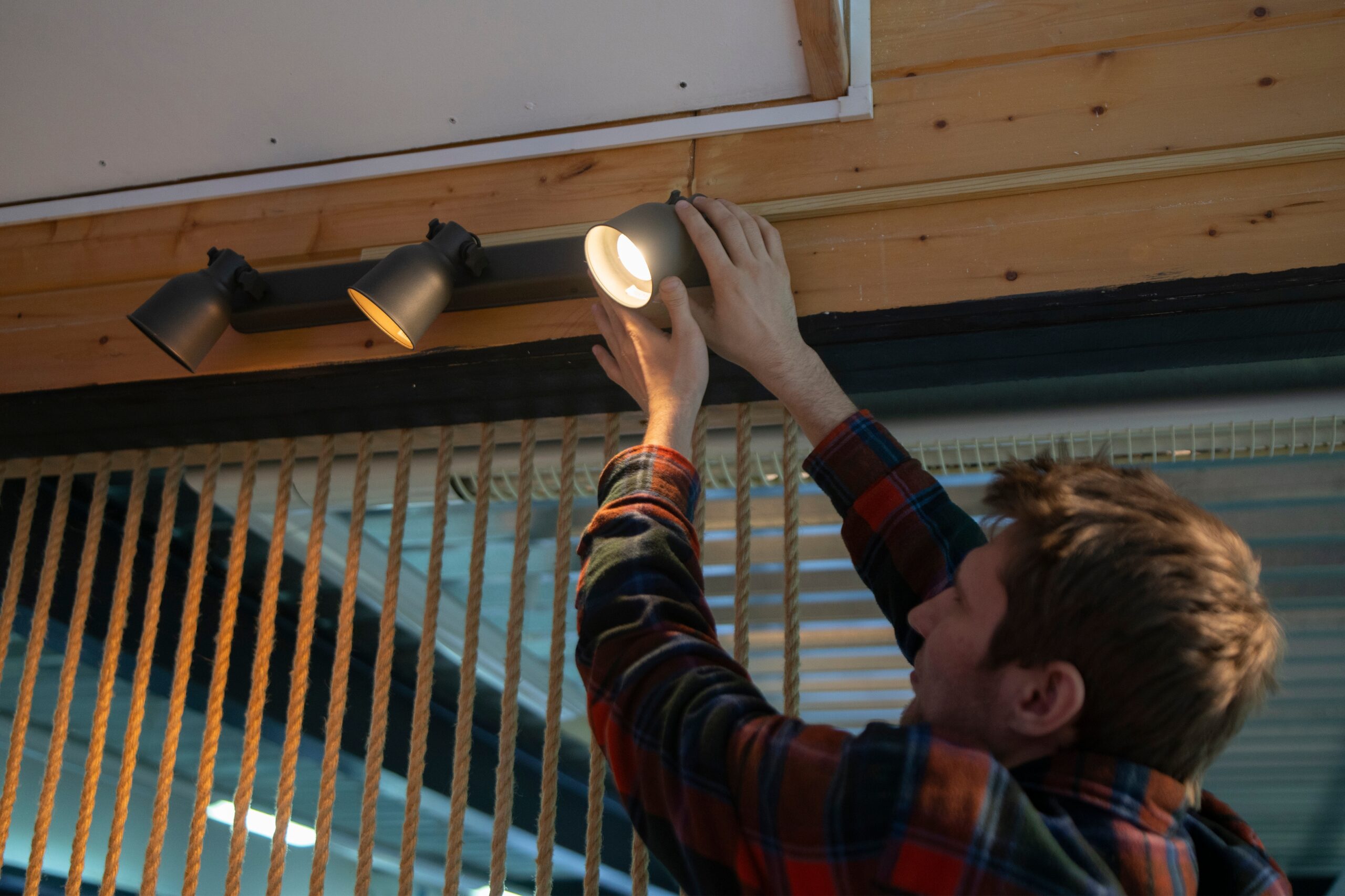 homeowner swapping out light bulb and inspecting light fixture