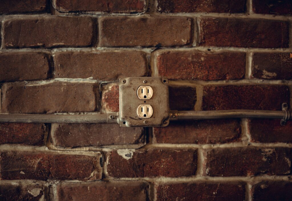 Electrical outlet installed on an brick wall of a residential building.